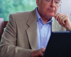 older man sitting at laptop